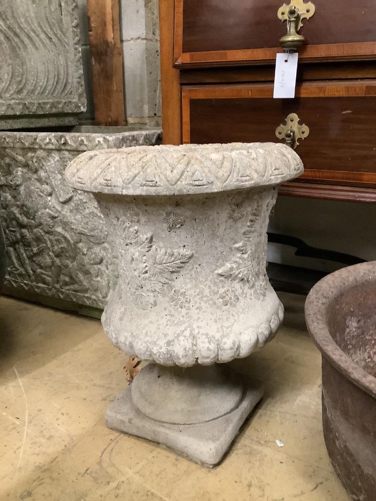 A reconstituted stone planter, height 44cm on base together with a circular cast iron garden planter, width 38cm